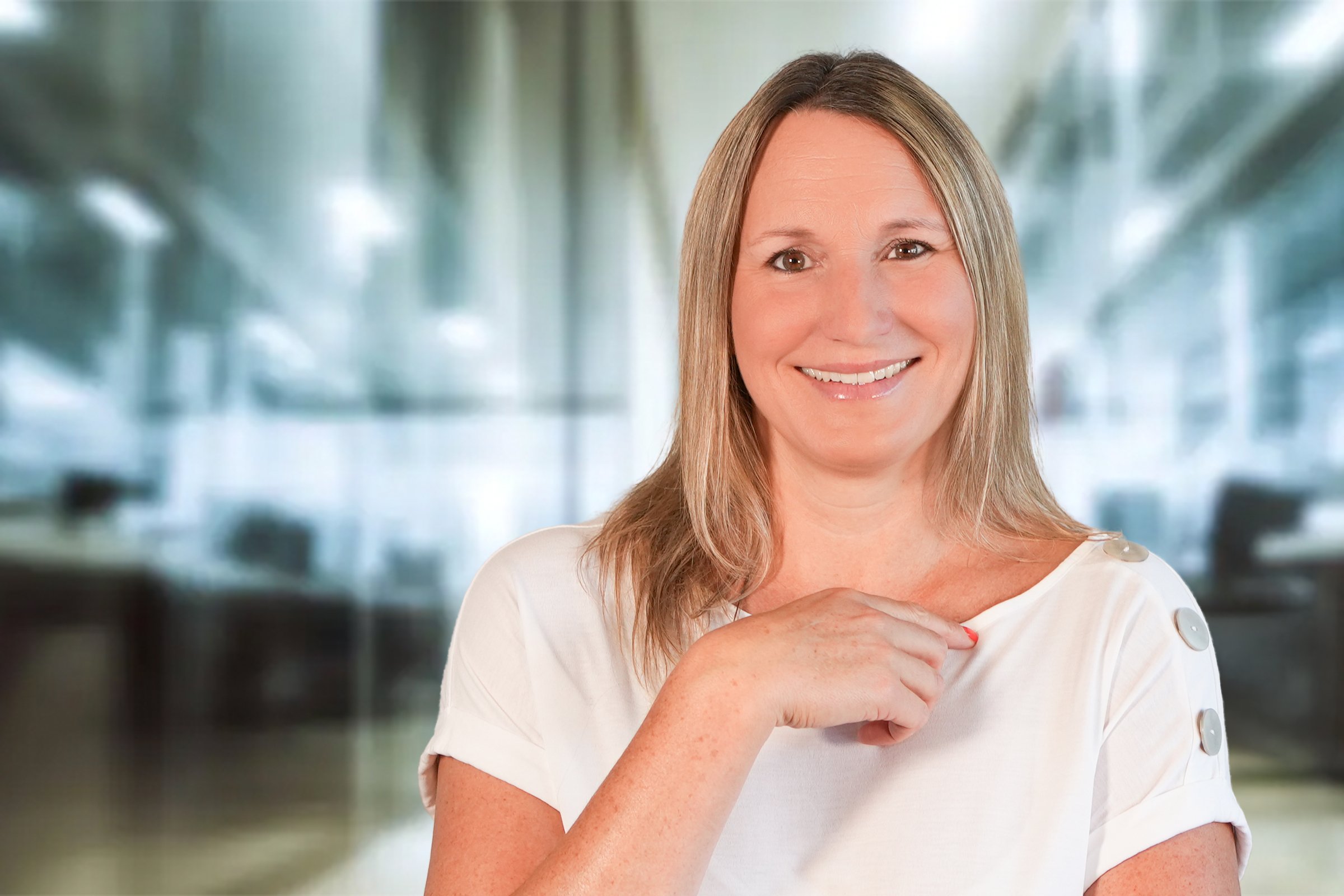 Corinna Bernard, Frau mit langen blonden Haaren und beigefarbenen Shirt