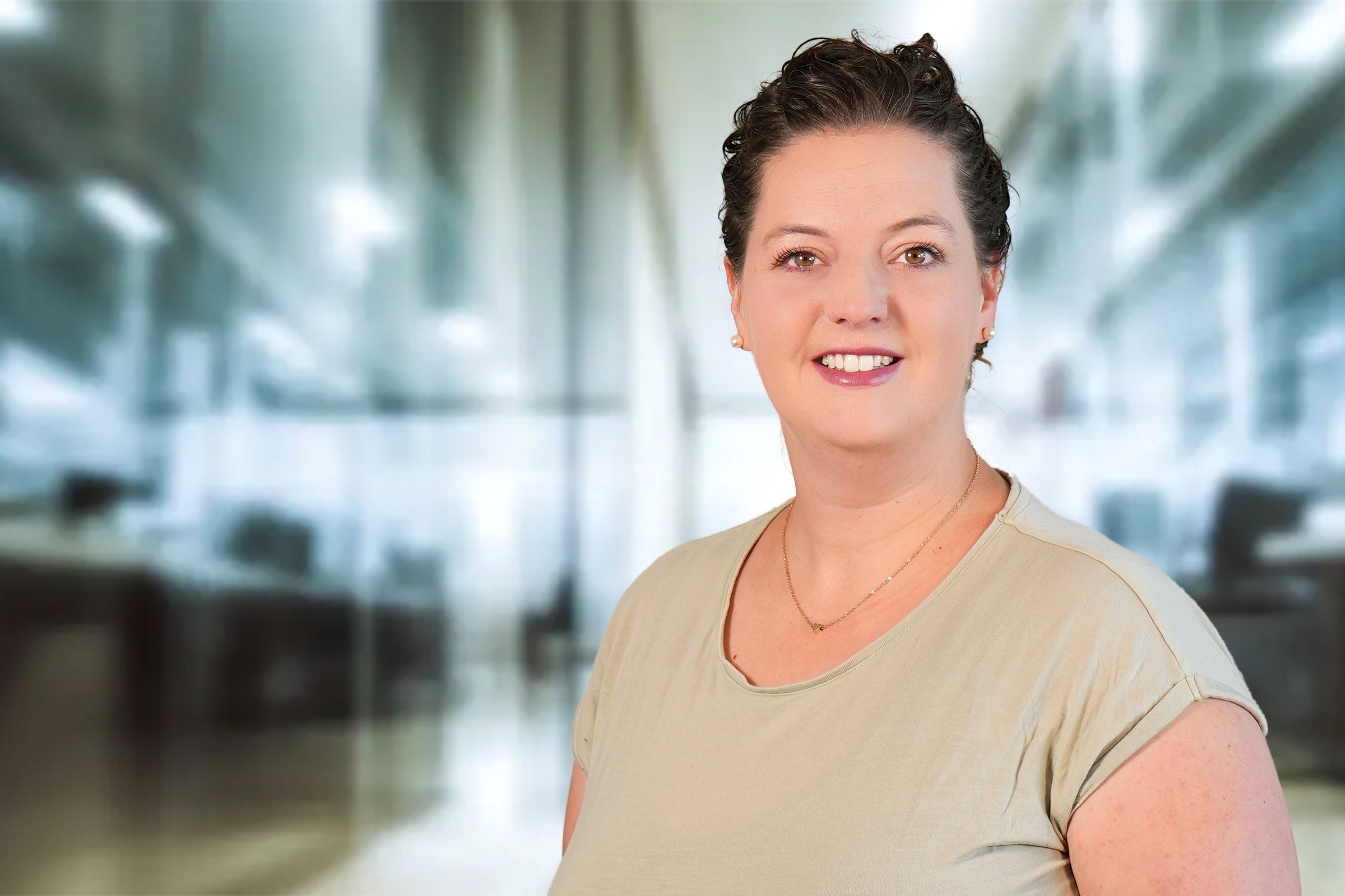 Hannah Fiedler, Frau mit dunklen kurzen Haaren im beigefarbenen Kurzarmshirt