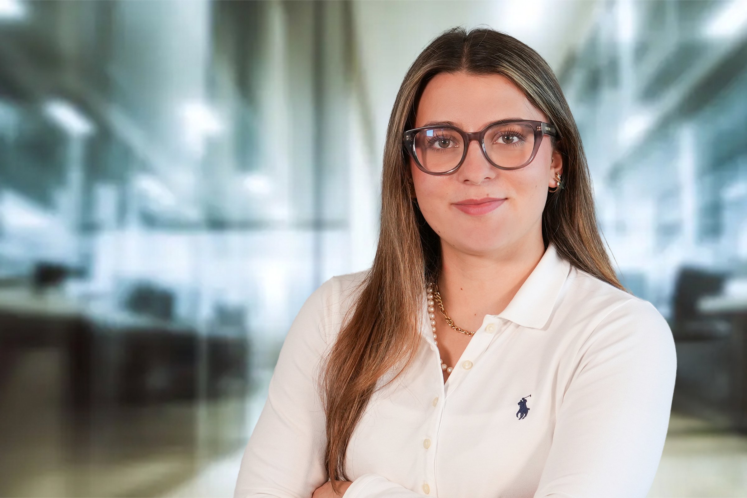Laura Holder, junge Frau mit mittelblonden, langen Haaren und Brille in cremefarbenen, Langarm Poloshirt