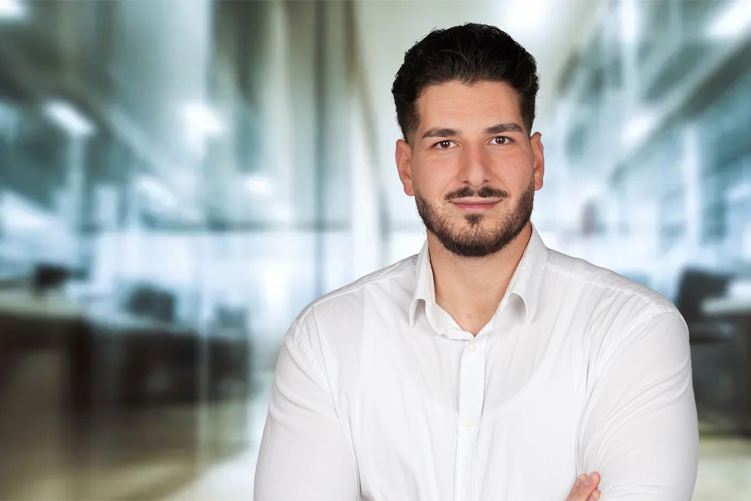 Yasemin Cevirgen, junger Mann mit dunklen Haaren und Bart mit weißem Langarmhemd
