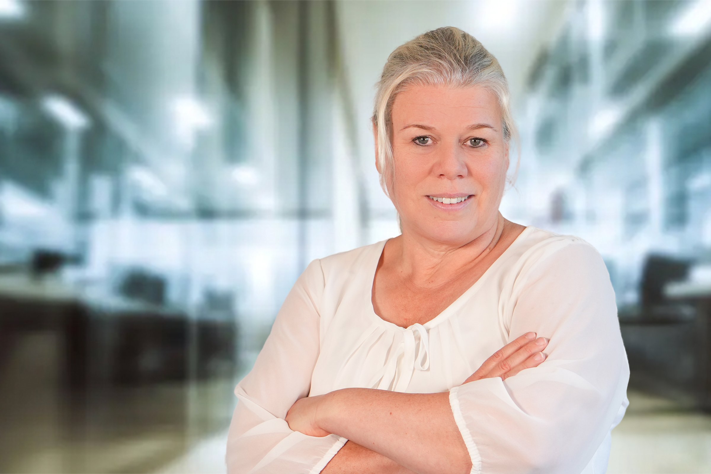 Silke Kasper, Frau mit blonden zum Zopf gebundenen Haaren im cremefarbenen Blusenshirt